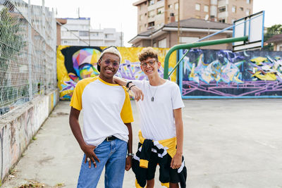 Two teenage boys standing and laughing on the urban basket court
