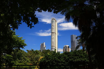 Low angle view of trees and buildings against sky