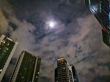 Low angle view of illuminated buildings against sky at night