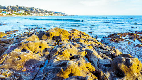 Scenic view of rocks on beach against sky