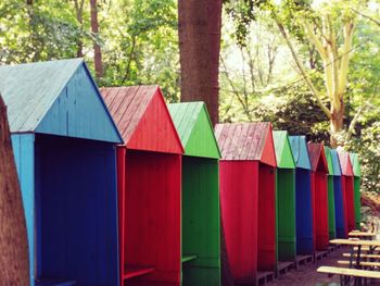 Multi colored umbrellas on beach by trees in forest