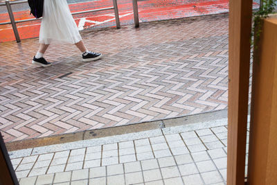 Low section of man walking on road