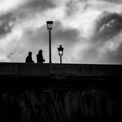 Low angle view of silhouette people against cloudy sky at dusk