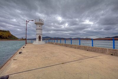 View of pier on sea against cloudy sky