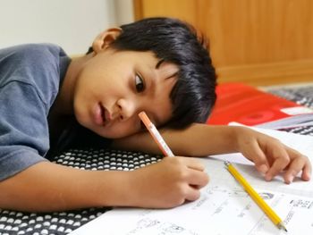 Boy writing in book at home