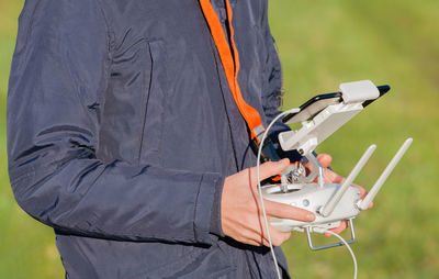 Midsection of man holding remote control