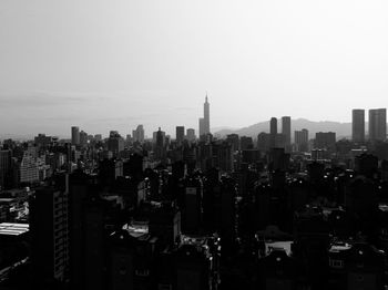 Aerial view of buildings in city against clear sky