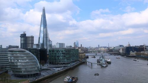 Modern buildings in city against cloudy sky