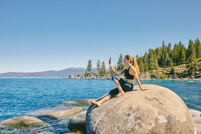 Young woman taking a picture of lake tahoe.