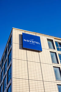 Low angle view of text on building against clear blue sky
