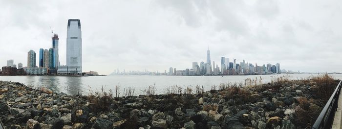 Panoramic view of sea and buildings against sky