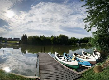 Boats moored in lake against sky