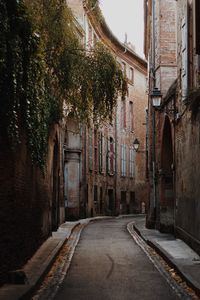 Empty road amidst buildings in city