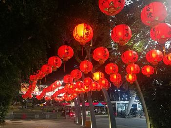 Low angle view of illuminated lanterns hanging against sky at night