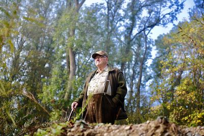 Low angle view of senior man standing in forest