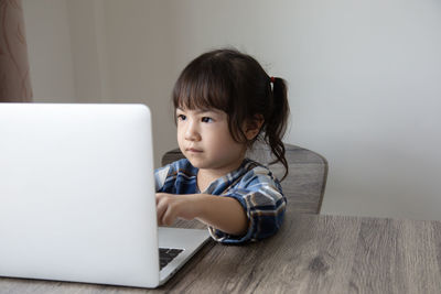 Portrait of cute girl sitting on table