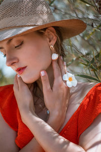 Close-up of young woman looking down by plant