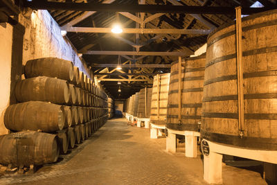 Barrels at illuminated wine cellar