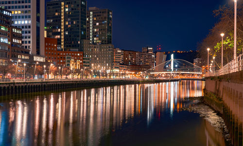 Cityscape of modern building in the night near the river and bridge. modern architecture office 