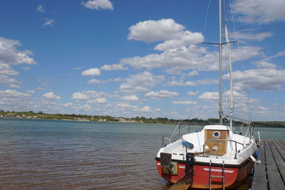 Sailboat moored on sea against sky