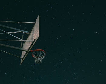 Low angle view of basketball hoop against sky at night