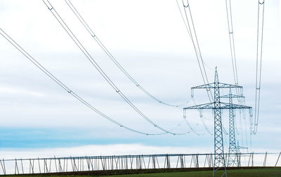 Low angle view of electricity pylon against sky