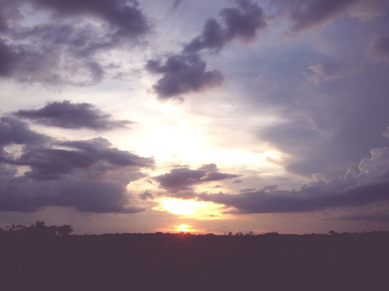 SCENIC VIEW OF SILHOUETTE FIELD AGAINST CLOUDY SKY