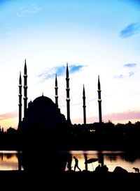Low angle view of silhouette mosque against sky