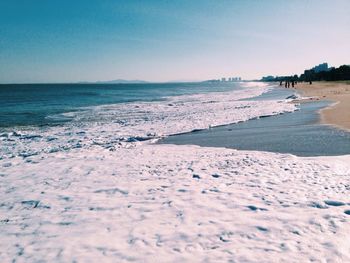 View of calm beach against clear blue sky