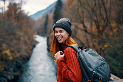 Portrait of young woman standing in forest during winter