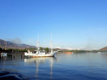 Sailboats in sea against clear blue sky