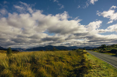 Scenic view of field against cloudy sky