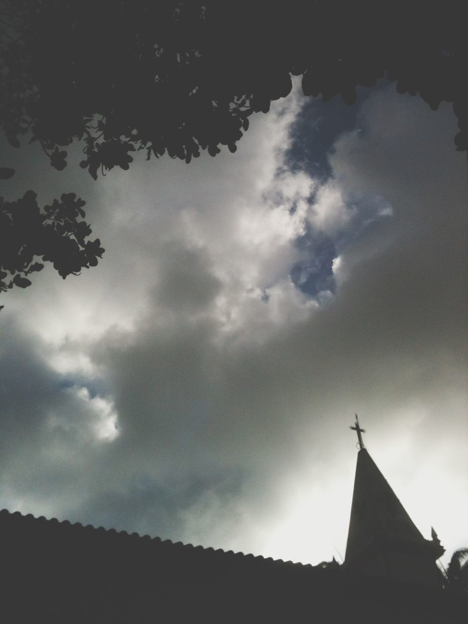 sky, low angle view, cloud - sky, cloudy, silhouette, cloud, sunbeam, sun, building exterior, built structure, architecture, sunlight, tree, nature, outdoors, day, weather, sunset, no people, beauty in nature