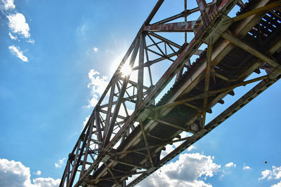 Low angle view of rustic bridge against sky