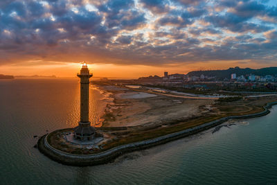 Aerial view of buildings against cloudy sky during sunset