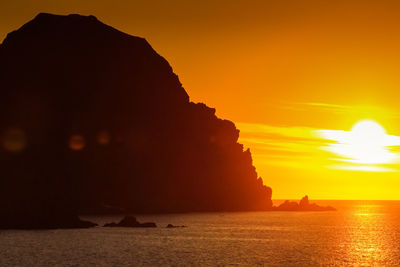 Scenic view of sea against orange sky