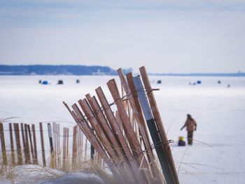 Wooden posts on beach against sky