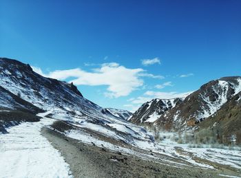 Scenic view of mountains against blue sky