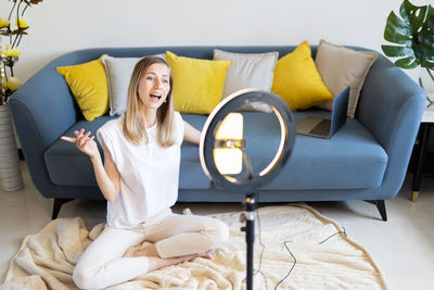 Portrait of woman sitting on sofa at home