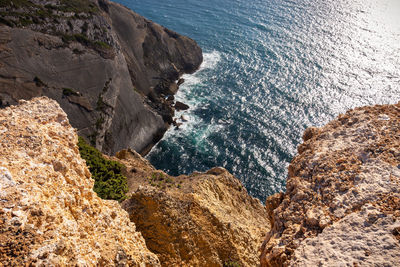 High angle view of rocks on sea shore