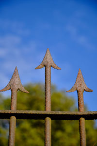 Close-up of metal fence against blue sky