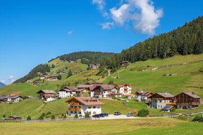 Houses on field by mountains against sky