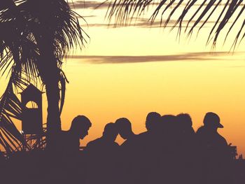 Silhouette of palm tree by sea against clear sky