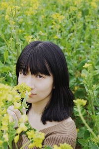 Portrait of woman smelling yellow flowers