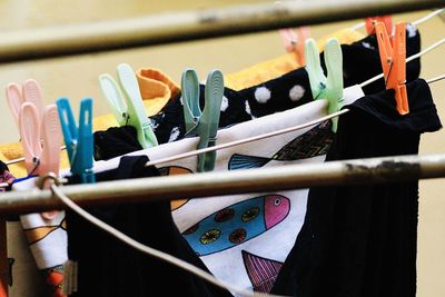 Close-up of clothespins hanging with clothes on clothesline