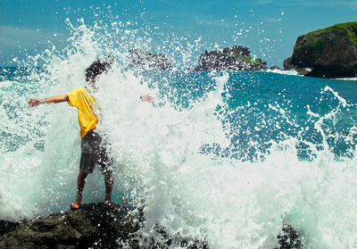 Man splashing water in swimming pool