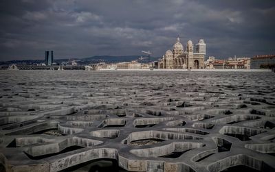 View of cityscape against cloudy sky