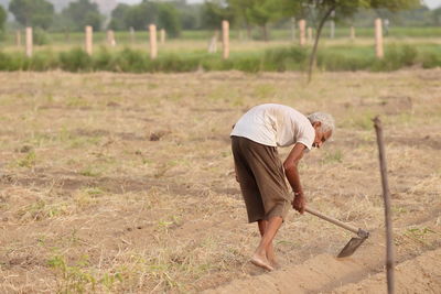 Side view of man working on field