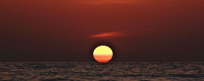 Scenic view of sea against orange sky