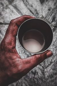 High angle view of hand holding coffee cup